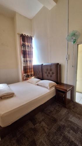 a bedroom with a large bed and a table at Viola in Bukittinggi