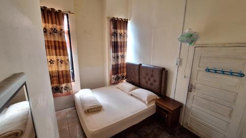 a small room with a bed and a window at Viola in Bukittinggi