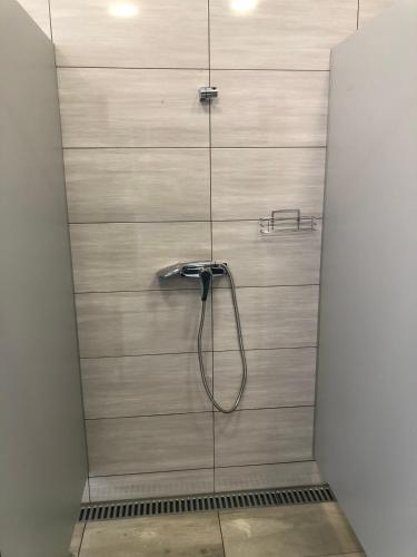 a shower with a hose in a shower stall at Glamping Stodoła Tent in Ściegny