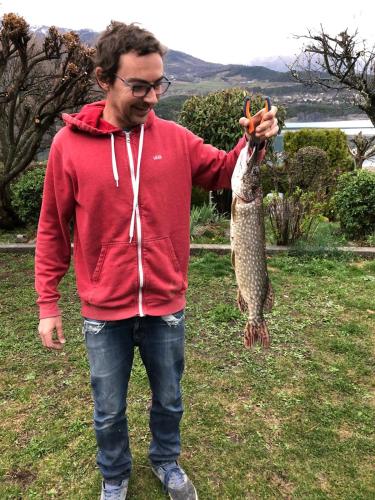 a man holding a large fish in his hand at Villa unique, 50 mètres du jardin au lac in Savines