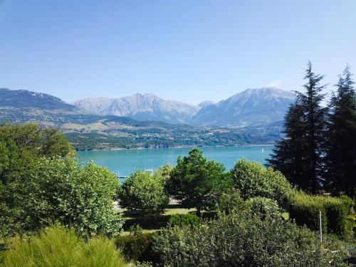 a view of a lake with mountains in the background at Villa unique, 50 mètres du jardin au lac in Savines