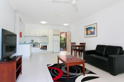 a living room with a couch and a table at Cairns City Palms in Cairns