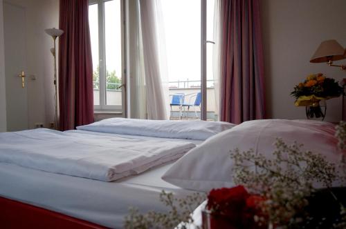 two beds in a hotel room with a window at Hotel Allegro Wien in Vienna