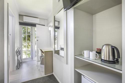 a kitchen with a counter and a table in a room at Nightcap at Skyways Hotel in Melbourne