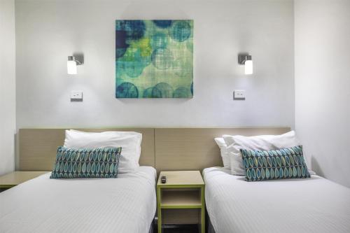 two beds sitting next to each other in a room at Nightcap at Skyways Hotel in Melbourne