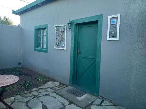 una puerta verde en el costado de un edificio en Mooi Uitsig Droom, en Beaufort West