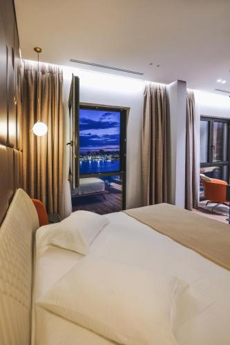 a hotel room with a bed and a large window at Hotel Saranda Butrinti, Affiliated by Melia in Sarandë