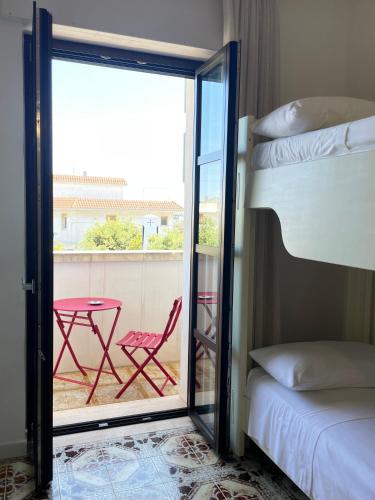 a room with a balcony with a table and a bed at Titanya - Bed And Breakfast Di Galatea Casa Vacanze in Corsano