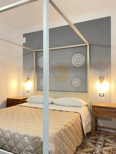 a bedroom with a canopy bed with two lamps and two tables at Titanya - Bed And Breakfast Di Galatea Casa Vacanze in Corsano