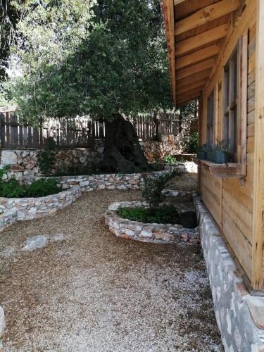 a backyard with a stone walkway next to a house at Restored stone house with terrace and gardens in Demre