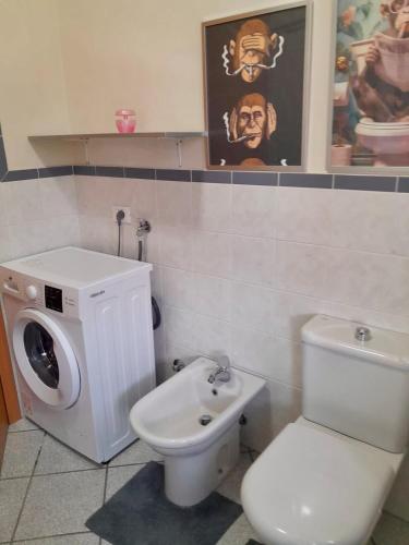 a bathroom with a toilet and a washing machine at Anisa Home 2 in Senna Comasco