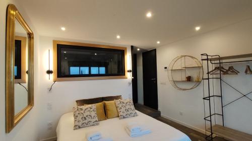 a bedroom with a bed with a mirror and a window at Mas des Buscades in Cabris