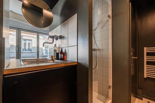 une salle de bain avec un lavabo et une fenêtre dans l'établissement L'Éclat Urbain - Studio dArchi Gare et Petite-France, à Strasbourg