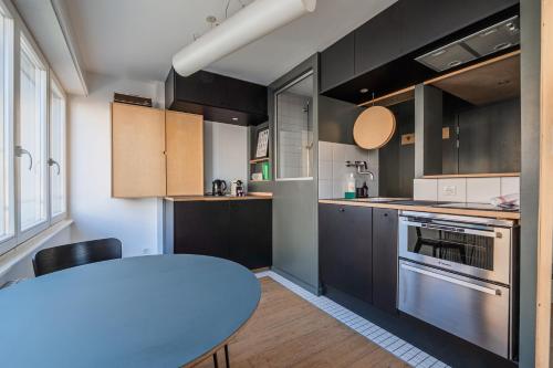 une cuisine avec une table et une table bleue dans l'établissement L'Éclat Urbain - Studio dArchi Gare et Petite-France, à Strasbourg