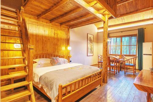 a bedroom with a bed and a table and chairs at Dayong Antique Feature Resort in Zhangjiajie