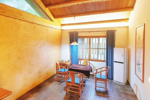 a room with a table and two chairs and a kitchen at Dayong Antique Feature Resort in Zhangjiajie