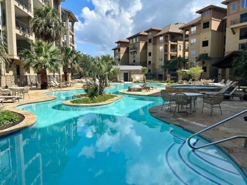 a swimming pool at a resort with blue water at Waterfront Condo for 4 with Resort Pool & Lake View in Horseshoe Bay