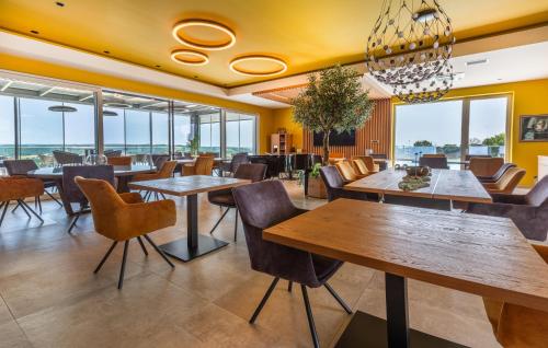 a restaurant with tables and chairs and windows at Beautiful Apartment In Rogasovci in Rogašovci