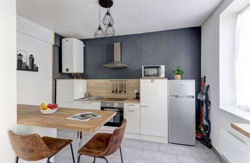 kuchnia ze stołem i lodówką w obiekcie Forêt Urbaine - Jolie T3 avec terrasse w mieście Montluçon