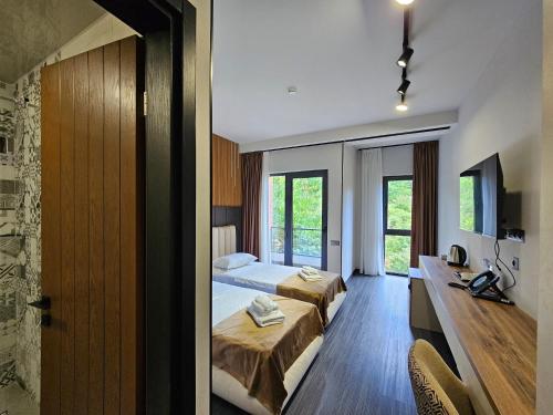 a hotel room with two beds and a television at Tskaltubo Epic Hotel & Spa in Tskaltubo