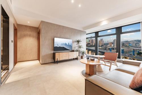 a living room with a couch and a tv at Xiyada Hotel（Chongqing Guanyinqiao） in Chongqing