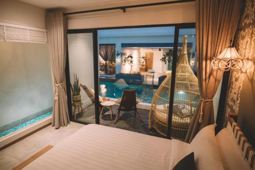 a bedroom with a bed and a view of a pool at La Villa Langkawi - Private Pool in Pantai Cenang