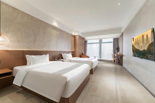 a hotel room with two beds and a table at Xiyada Hotel（Chongqing Guanyinqiao） in Chongqing