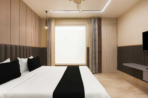 a bedroom with a large bed with a large window at Townhouse Hisar in Hisār