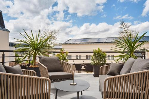 a patio with chairs and a table and a building at The Originals Boutique, Hôtel Les Coulisses du Théâtre, Saint-Quentin in Saint-Quentin