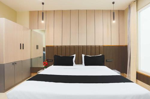 a bedroom with a large white bed with black pillows at Townhouse Hisar in Hisār