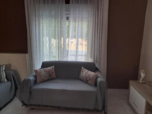 a couch in a living room with a window at Chris Apartment in Mélissa