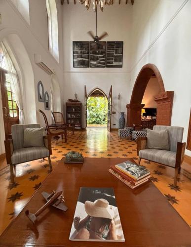 a living room with two chairs and a table at The Postcard Saligao in Calangute