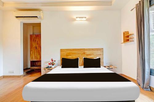 a bedroom with a large white and black bed at Hotel O Sector 49 Sohna Road in Gurgaon