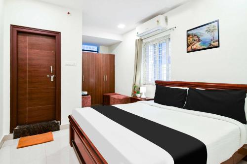 a bedroom with a bed and a wooden door at Hotel O Madhapur in Hyderabad
