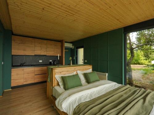 a bedroom with a bed and a large window at ForestView 1- Romantic Cabin for 2 in Fuereşti