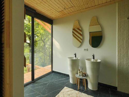 a bathroom with two sinks and a surfboard on the wall at ForestView 1- Romantic Cabin for 2 in Fuereşti
