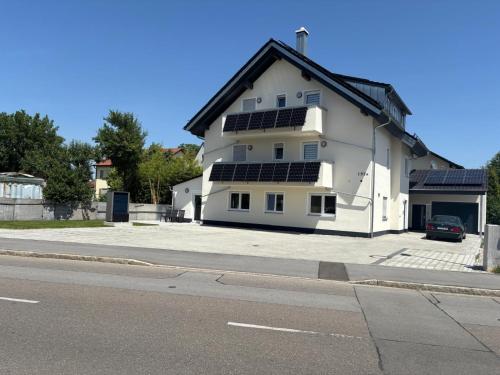 a white house with solar panels on the side of it at Boardinghaus Koucha - Wohnen auf Zeit in Neuburg an der Donau