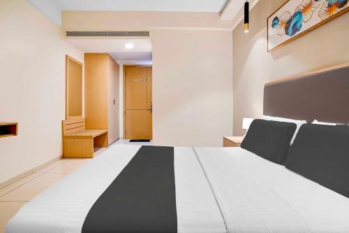 a bedroom with a large black and white bed at Hotel O Metro Park Opposite Kalasipalya Bus stand in Bengaluru