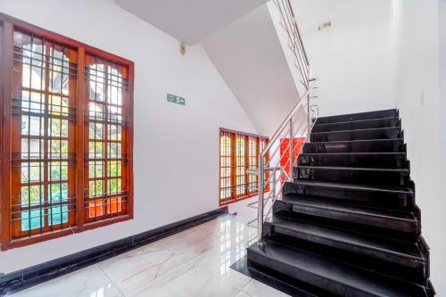 a staircase in a room with two windows at Hotel O City Center Ernakulam in Cochin