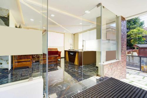 a glass shower door in a room with a table at Collection O Padmanabhaswamy Temple Trivandrum in Trivandrum