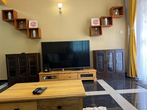 a living room with a flat screen tv on a table at The Oasis in Buwate
