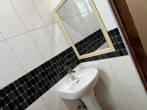 a bathroom with a sink and a mirror at The Oasis in Buwate