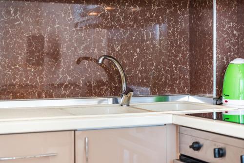 a kitchen with a sink and a faucet at Orikum Seaview Family Stay in Vlorë