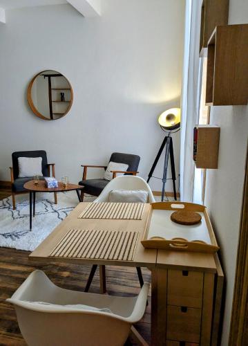 Cette chambre comprend une table, des chaises et un miroir. dans l'établissement Studio cosy et spacieux, à Carcassonne