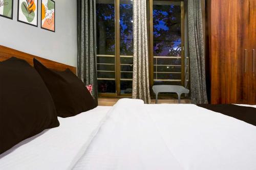 a bedroom with a white bed and a window at Townhouse Viman Nagar in Pune