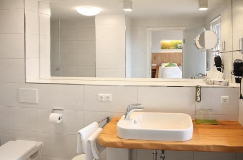 a white bathroom with a sink and a mirror at AKZENT Hotel Altes Casino in Fulda