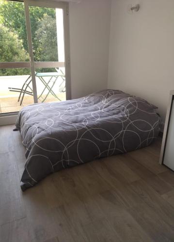 - un lit avec une couette noire dans l'établissement Studio Saint Georges de Didonne, à Saint-Georges-de-Didonne