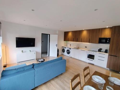 a living room with a blue couch and a kitchen at #22, Free parking, Self check-in, Perfect location for Katowice, Chorzow, and DTS, 3rd floor - no elevator in Chorzów