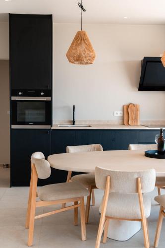 a dining room with a table and chairs and a kitchen at VAKANTIEDOMEIN DOUVE in Heuvelland