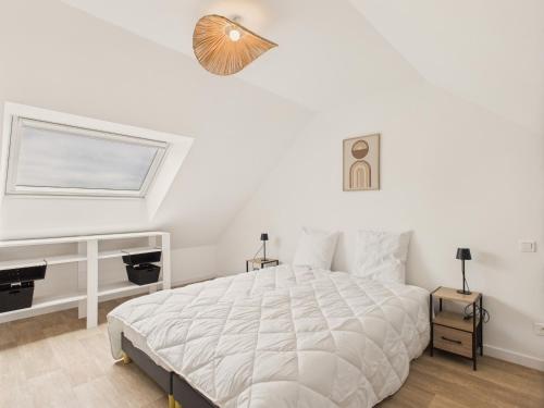a white bedroom with a bed and a window at Maison familiale pour 10 à Fréhel avec jardin in Frehel